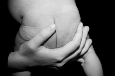A mother holding her baby by its derriere. A mother holding her baby by its derriere.