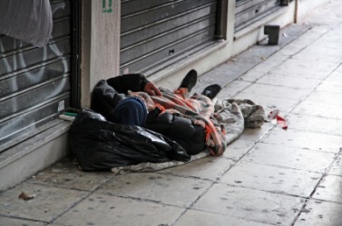 A destitute man sleeps on the street. A destitute man sleeps on the street.