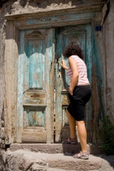 Before entering, the woman pauses with her foot on the doorsill. Before entering, the woman pauses with her foot on the doorsill.