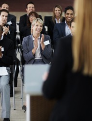 A group applauding a speaker. A group applauding a speaker.