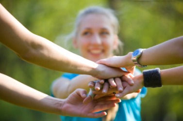 A group of people clasping hands in mutual encouragement. A group of people clasping hands in mutual encouragement.