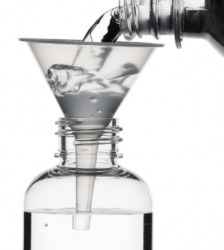 Water being poured through a funnel into a bottle. Water being poured through a funnel into a bottle.