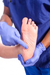 A doctor holding his patients heel. A doctor holding his patients heel.