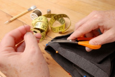 A woman puts a hem on a garment. A woman puts a hem on a garment.