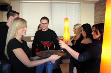 A hostess serving drinks to her guests. A hostess serving drinks to her guests.