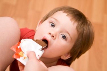 A child receives a treat from an indulgent parent. A child receives a treat from an indulgent parent.