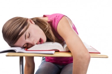 A girl lies inert on her desk. A girl lies inert on her desk.