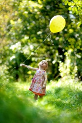 A child holding a balloon. A child holding a balloon.