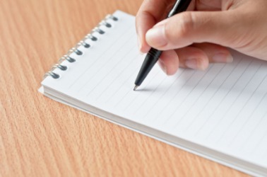 A woman jots a quick note. A woman jots a quick note.