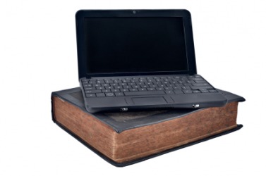 A laptop computer juxtaposed over a book. A laptop computer juxtaposed over a book.