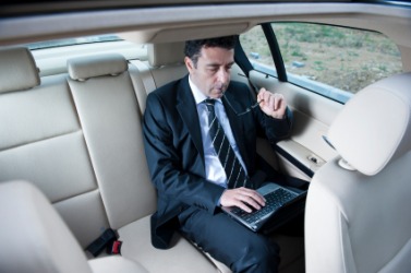 A man sits in the backseat or rear of a car. A man sits in the backseat or rear of a car.