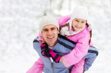 A father gives his daughter a piggyback ride. A father gives his daughter a piggyback ride.