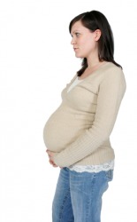 This pregnant woman's sweater is needing to stretch. This pregnant woman's sweater is needing to stretch.
