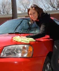 A woman applying wax to her car. A woman applying wax to her car.