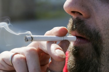 A man puffs a cigarette. A man puffs a cigarette.