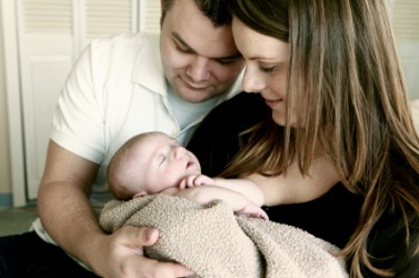 This baby is the focus of her parents attention. This baby is the focus of her parents attention.