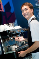 A young barista making coffee. A young barista making coffee.