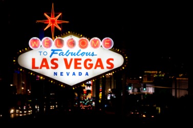 Las Vegas at night seen behind the city sign. Las Vegas at night seen behind the city sign.