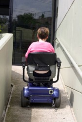 A woman using a wheelchair ramp. A woman using a wheelchair ramp.