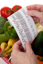 A woman holds a grocery receipt. A woman holds a grocery receipt.
