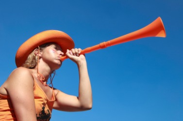 A young woman blows a vuvuzela. A young woman blows a vuvuzela.