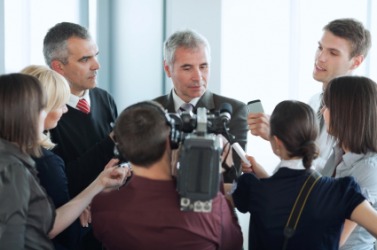 A man faces a barrage of reporters. A man faces a barrage of reporters.