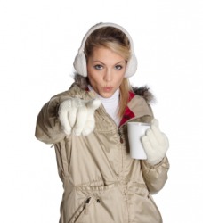 A woman wearing a beige colored coat. A woman wearing a beige colored coat.