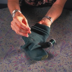 A woman darns a sock. A woman darns a sock.