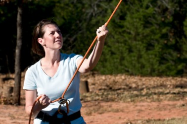 A woman belaying on a ropes course. A woman belaying on a ropes course.