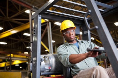 This person is manning a forklift. This person is manning a forklift.