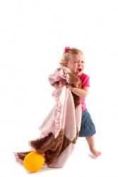 An unhappy child hugs her security blanket. An unhappy child hugs her security blanket.