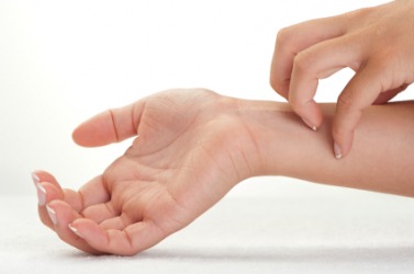 A woman scratches her wrist. A woman scratches her wrist.