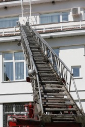 A firetrucks aerial ladder extended to a building. A firetrucks aerial ladder extended to a building.