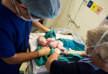 Doctors checking a newborn to determine its Apgar score. Doctors checking a newborn to determine its Apgar score.