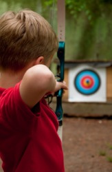 A young boy practicing archery. A young boy practicing archery.
