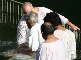 A man being baptized in a river. A man being baptized in a river.