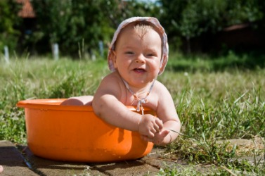 A baby playing in a basin. A baby playing in a basin.