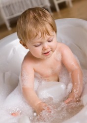A child having a bath in a bathtub. A child having a bath in a bathtub.