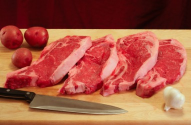 Four beef steaks on a cutting board. Four beef steaks on a cutting board.