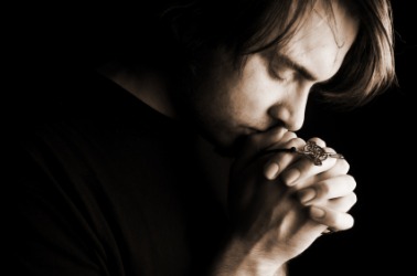 A man expresses his belief in God through prayer. A man expresses his belief in God through prayer.