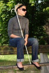 A blind woman sitting on a fence. A blind woman sitting on a fence.