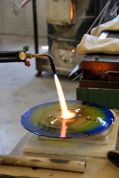 A glass artist using a blowtorch. A glass artist using a blowtorch.