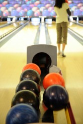 A woman bowling in a bowling alley. A woman bowling in a bowling alley.
