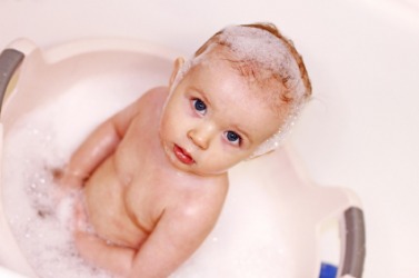 A baby in a bubble bath. A baby in a bubble bath.