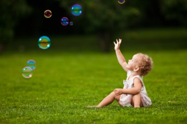 A baby playing with bubbles. A baby playing with bubbles.