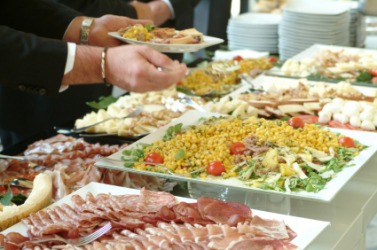 People serving themselves at a buffet. People serving themselves at a buffet.