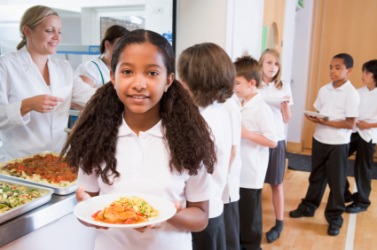 Children getting their lunch in a cafeteria. Children getting their lunch in a cafeteria.