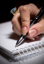 A woman writing in a cahier. A woman writing in a cahier.