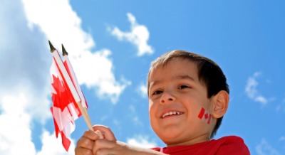 A little boy with flags to celebrate Dominion Day or Canada Day. A little boy with flags to celebrate Dominion Day or Canada Day.