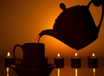 Pouring tea by candlelight. Pouring tea by candlelight.